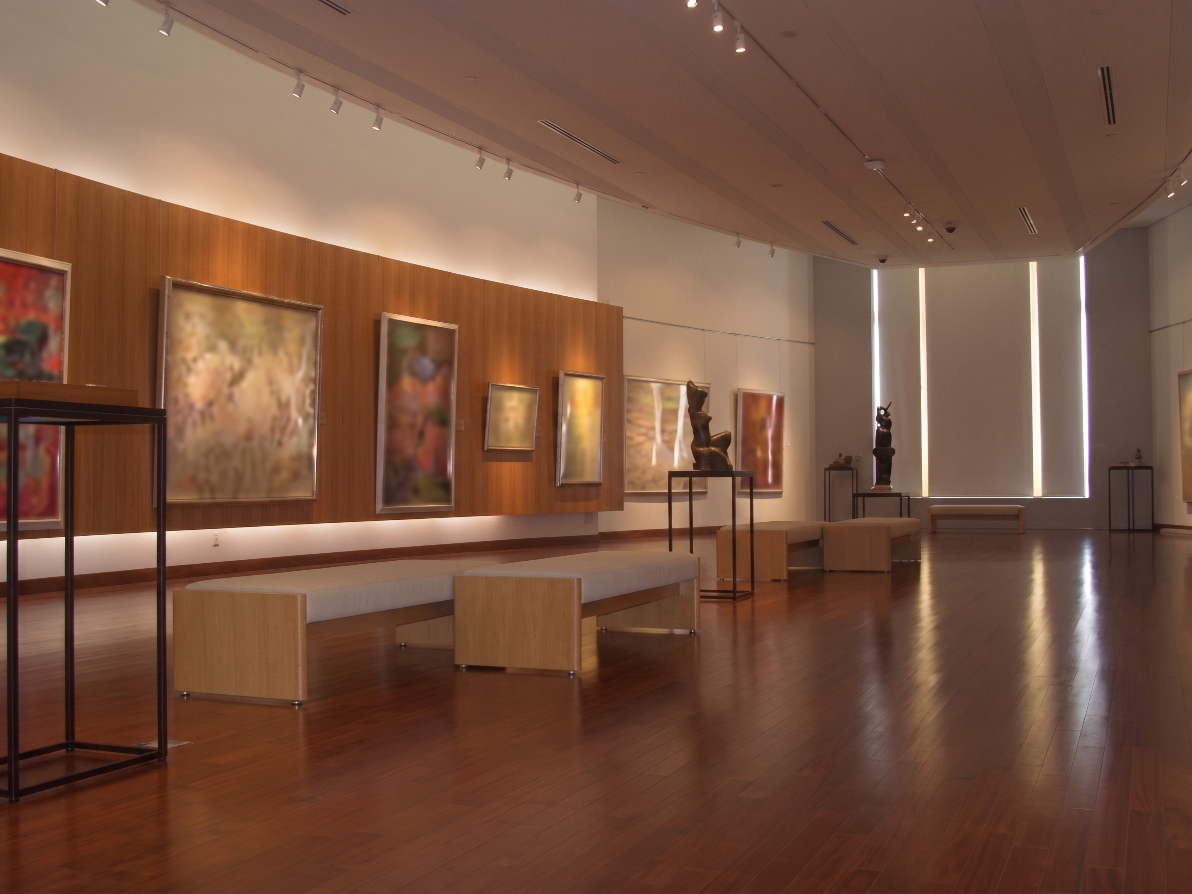 木製の展示台とベンチを備えた美術館の展示室