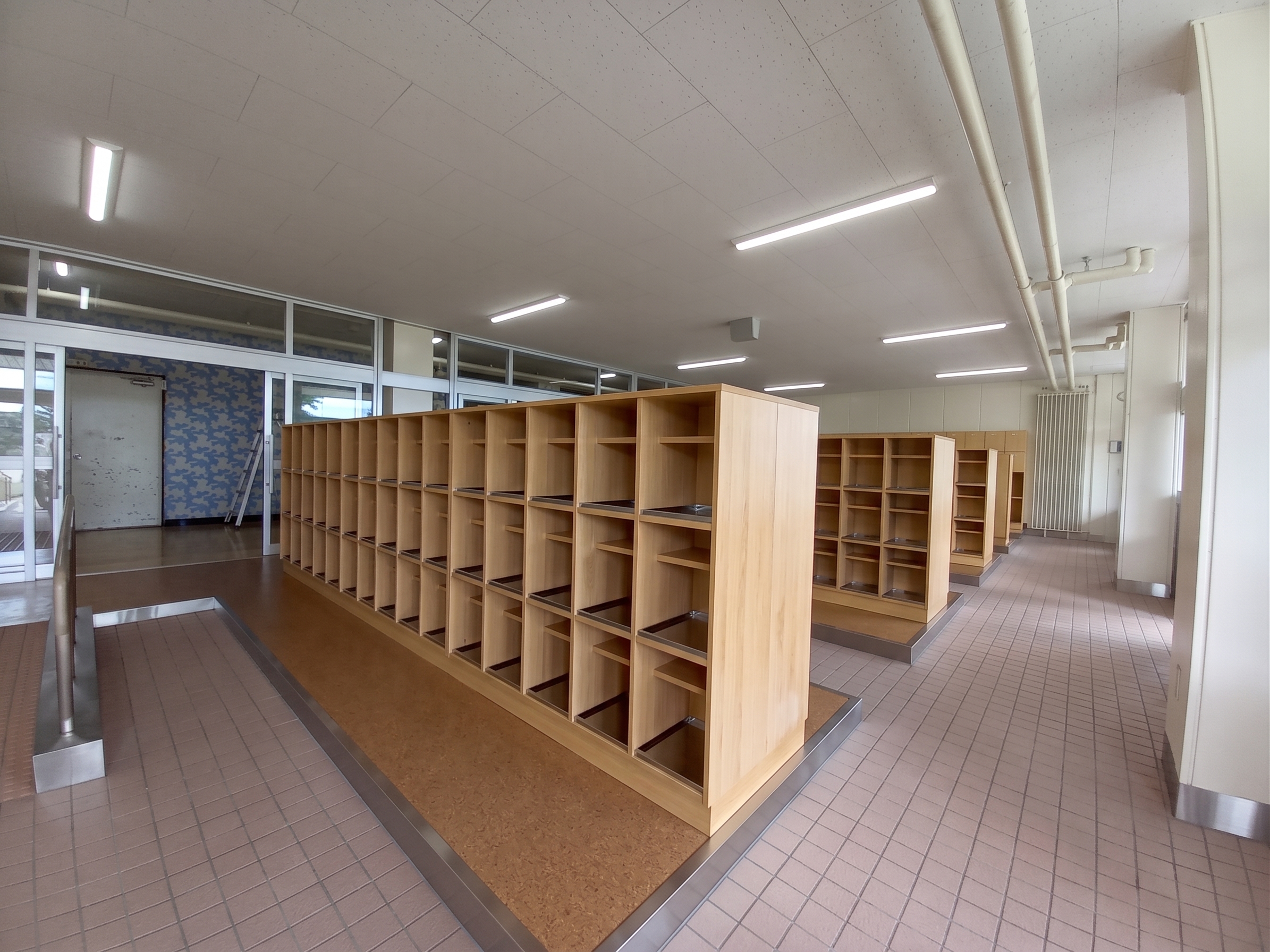 廊下に沿って連続する木製下足棚の全景